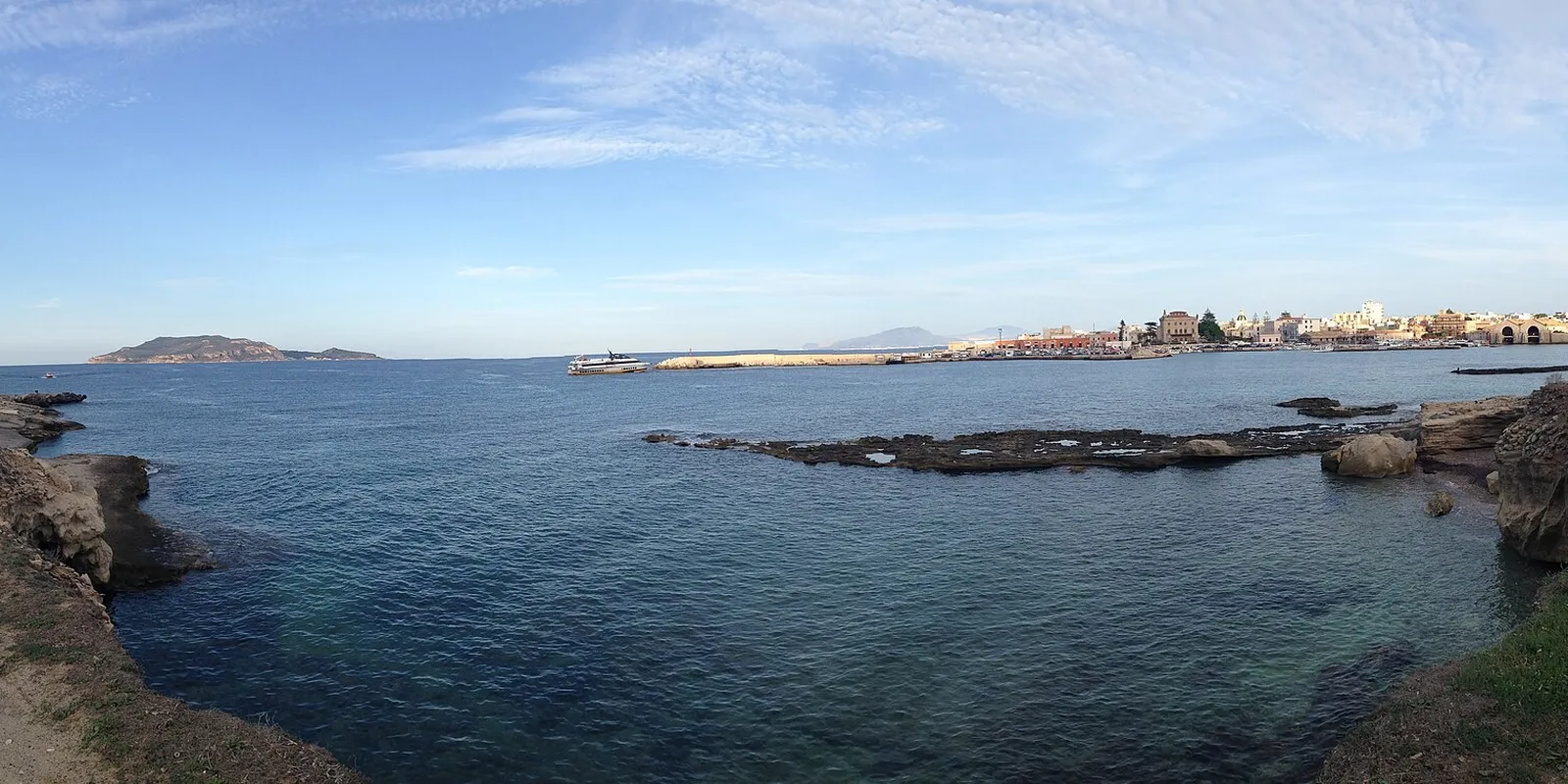 Costa rocciosa e porto di Favignana in una giornata limpida fuori stagione